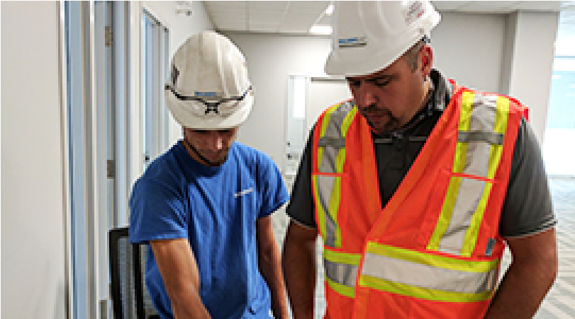 employees standing together wearing hard hats