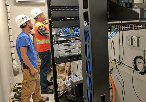 Asset-30@3x-100.jpg employees working on cabling at a business
