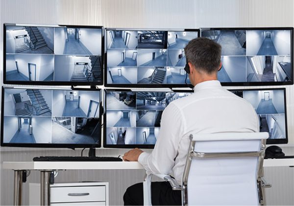 Asset-34@3x-100.jpg an employee viewing security cameras on monitors